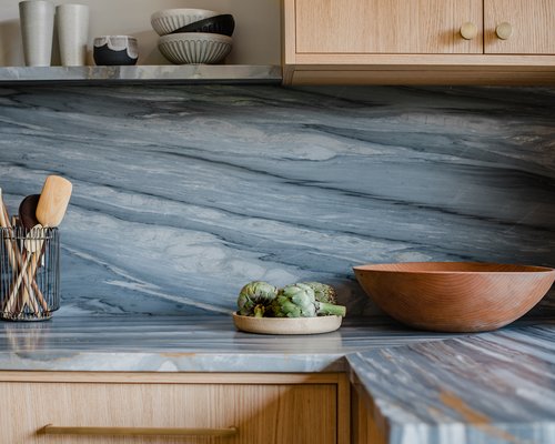 Close-up of marble-look backsplash and wooden accessories in kitchen renovation