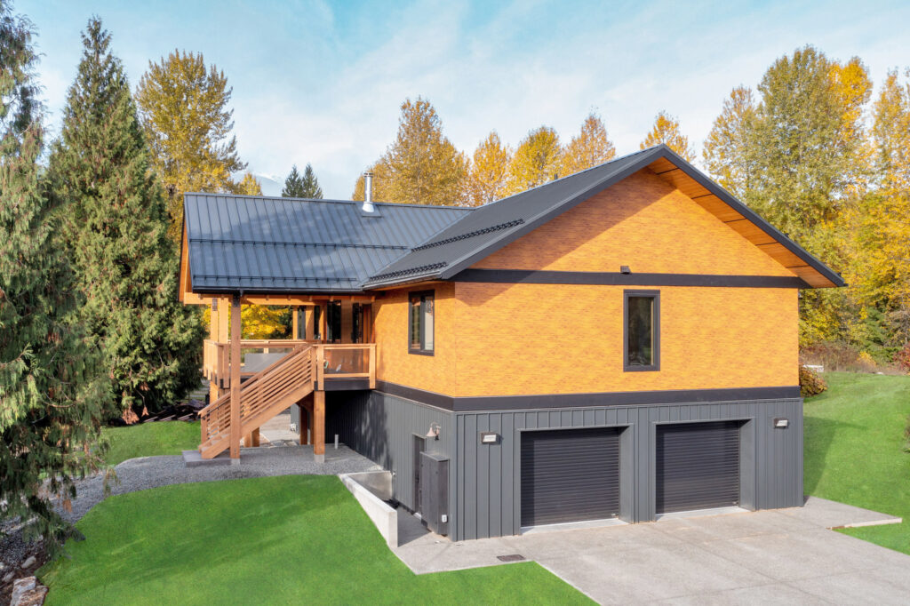 Rear view of the home with a landscaped yard and modern glass railing