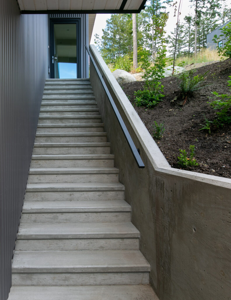 Concrete staircase Concrete staircase with glass railings leading to main entrance of the home