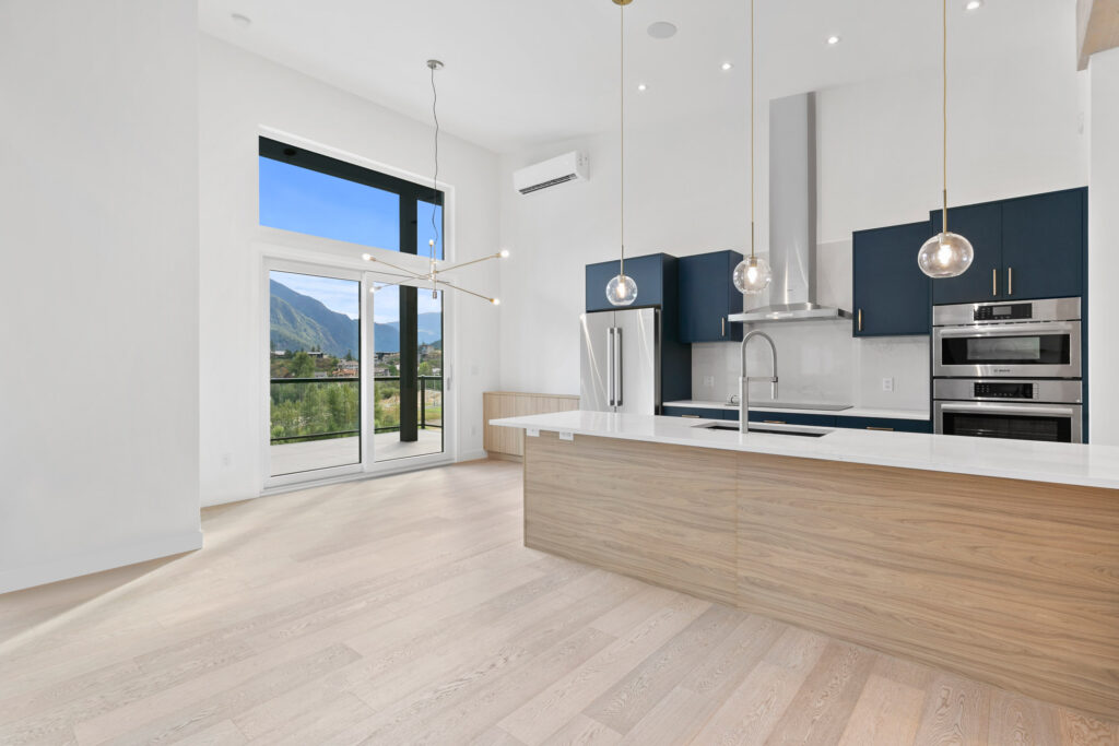 Modern kitchen with navy cabinetry Modern kitchen with navy cabinetry, Caesarstone countertops, and pendant lighting over island