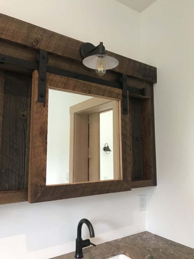 Detail of mirror lighting and tile backsplash in bathroom