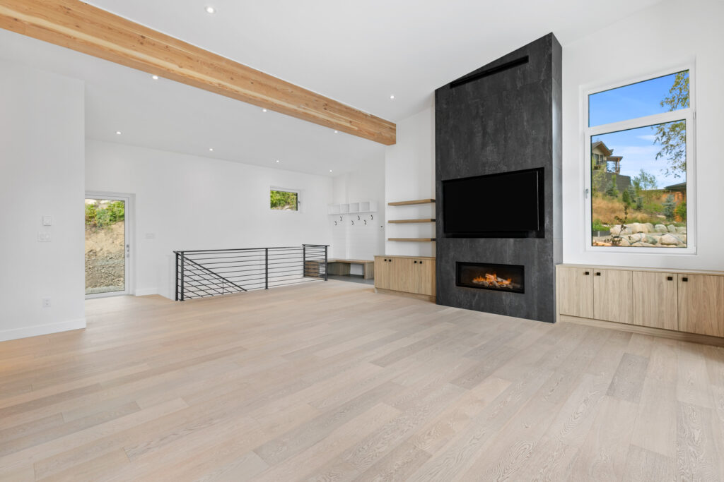 Living Room Spacious living area with exposed timber beams, floor-to-ceiling fireplace, and wide-plank oak floors