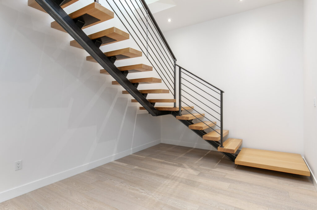 Staircase Floating staircase with steel railing and light oak treads engineered by One Sixty-Fourth Design