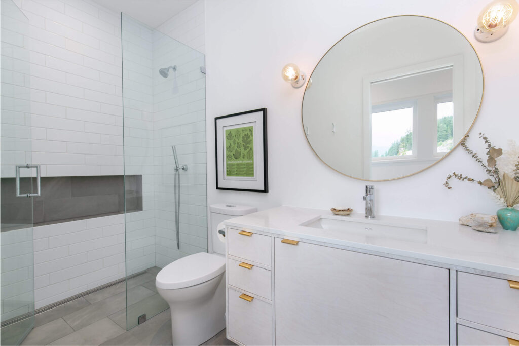 Modern ensuite bathroom with round mirror and light accents