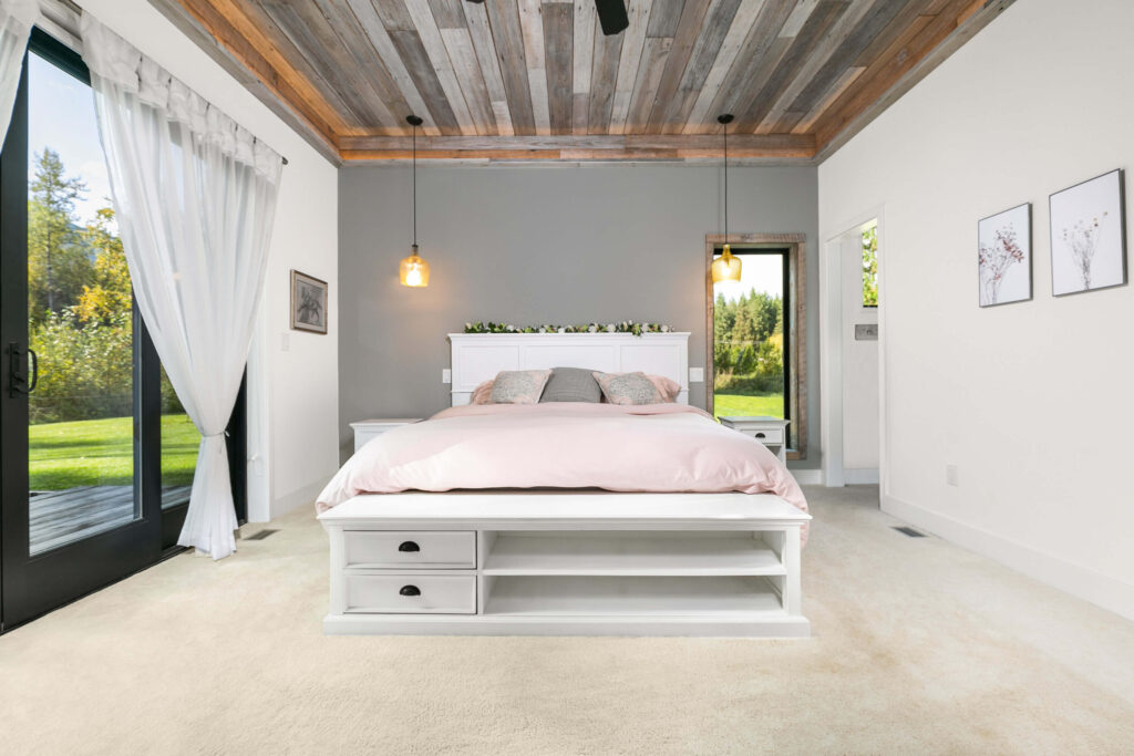Primary bedroom with barnboard ceiling and sliding glass door