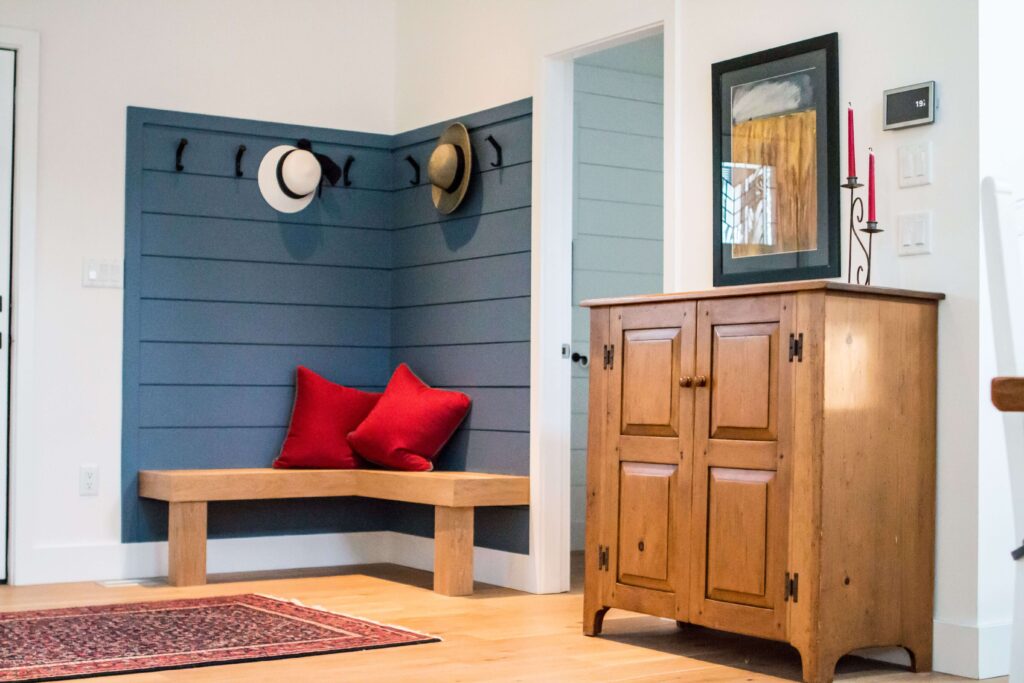 Foyer with built-in wood bench and blue accent wall