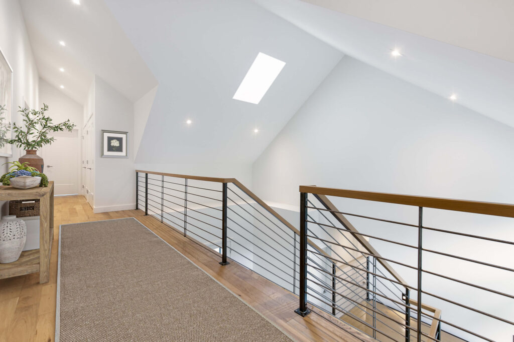 Modern hallway featuring skylight and railing