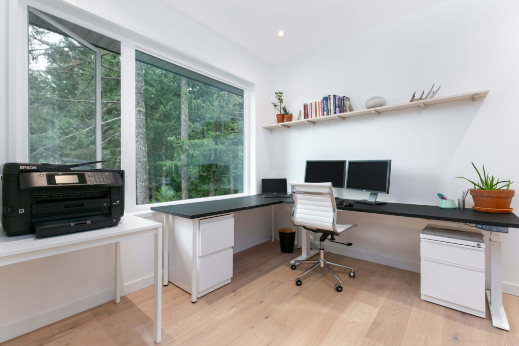 Home office setup with two desks and large windows
