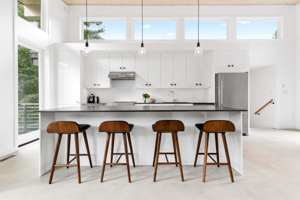 Modern kitchen featuring bar stools and white cabinetry