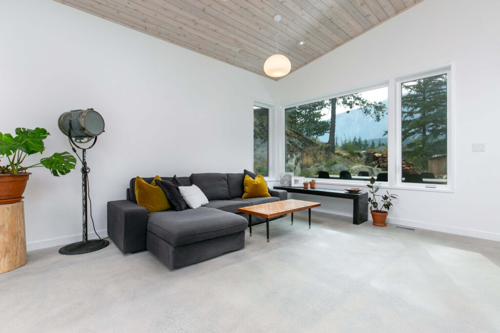 Bright living room with large windows and forest view