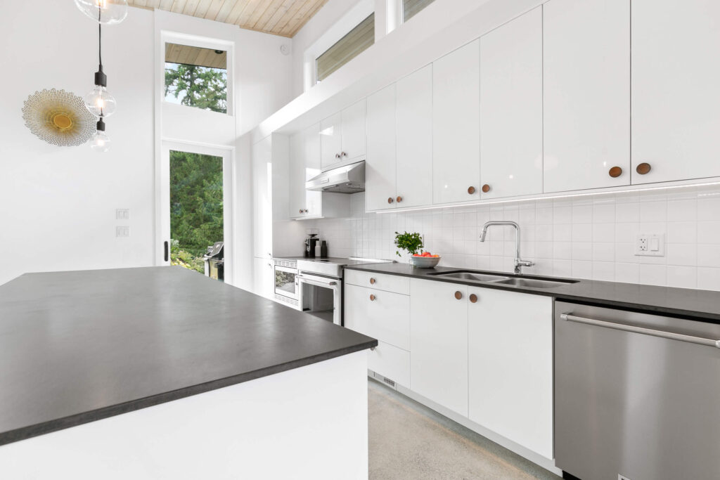 Contemporary kitchen with white cabinetry and black countertop
