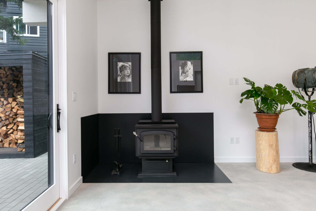 Wood-burning stove in living area with white walls