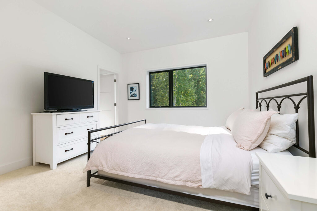 Bright secondary bedroom with large window and neutral tones