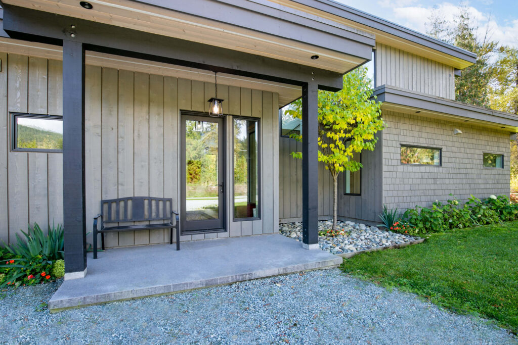 Custom wood front door with black hardware and covered entry